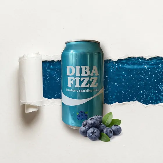 A turquoise drink can lying on white paper with a torn strip behind it revealing blue sparkling water and a few blueberries beside it